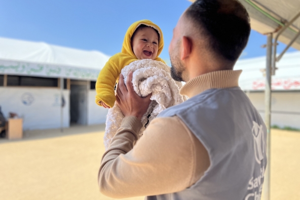 Sameer, 6 Months, with Ali, Save the Children staff, during baby kit distribution in Gaza